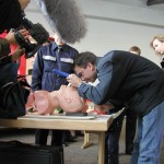 Ein Besucher probiert das intubieren mit einem Laryngoskop an einer Puppe.<br> © Merlin Wolf