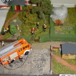 Feuer Klein, brennt Komposthaufen. Ein LF 16/12 der Freiwilligen Feuerwehr bei der Brandbekämpfung mit dem Schnellangriffsschlauch.