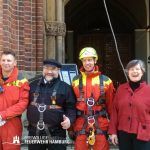 Landesfeuerwehrpastorin Erneli Martens zusammen mit dem Küster Martin Meier sowie zwei Kollegen der SEG Höhenrettung.